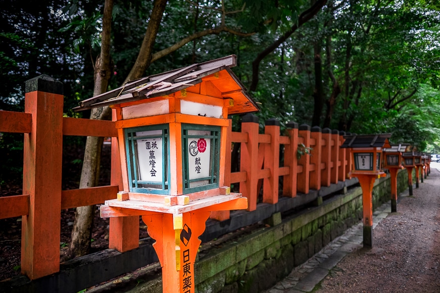 An orange fence lined with Japanese letter boxes 