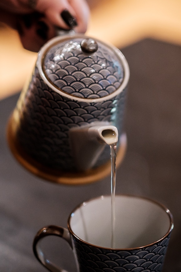 Teapot pouring water into a teacup