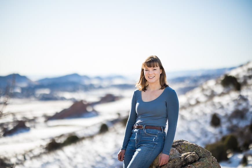 Woman sitting on rock in snow