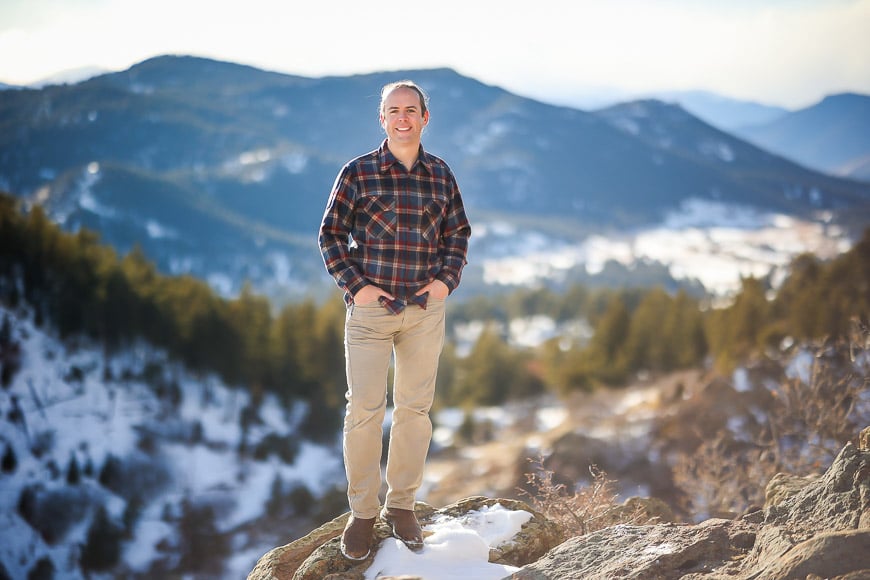 Full length portrait of a man standing on rocky mountain scene