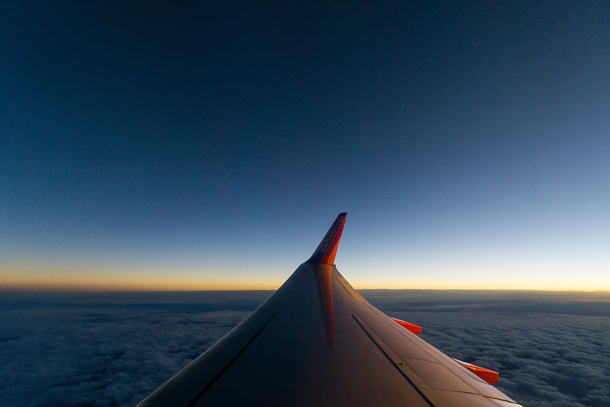 Airplane wing over cloudy horizon