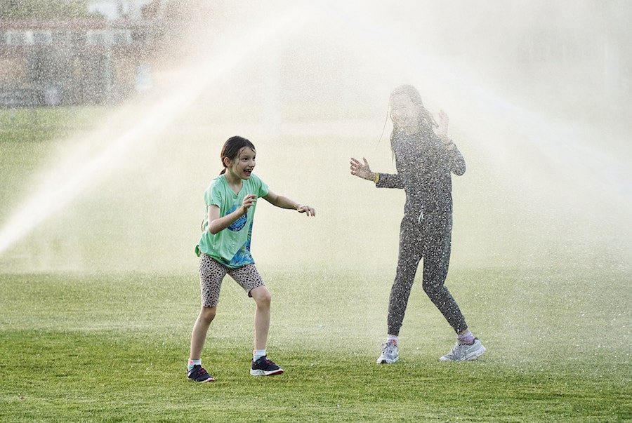 Kids playing in sprinklers